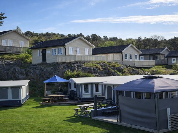 Campingvogner med fortelt nedenfor hyttene