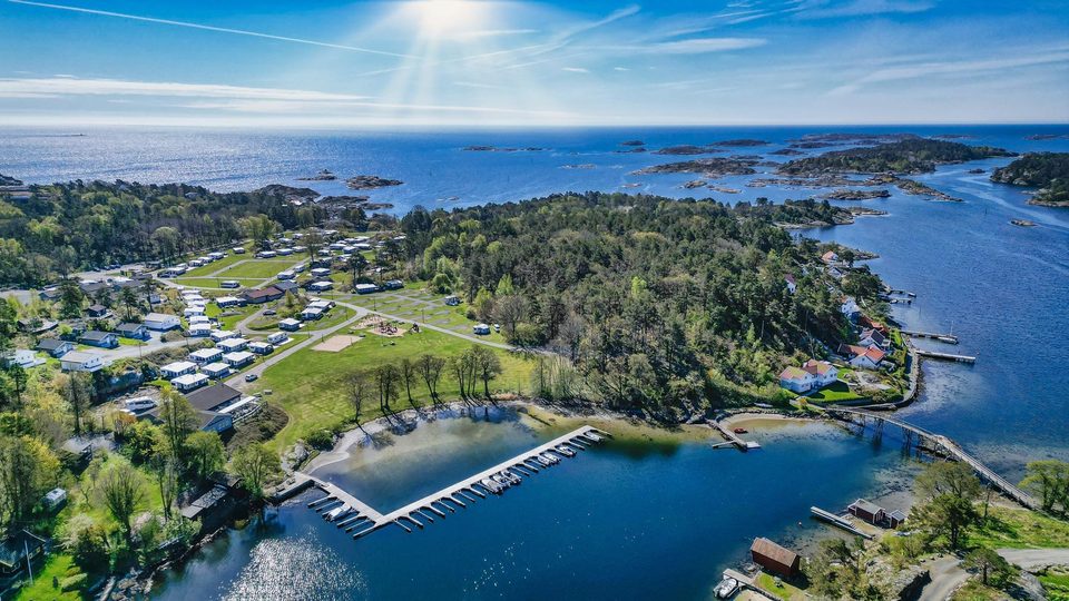 Marivold Camping sett fra lufta: hytter, campingplasser og brygge ved sjøen, med skjærgården rundt.